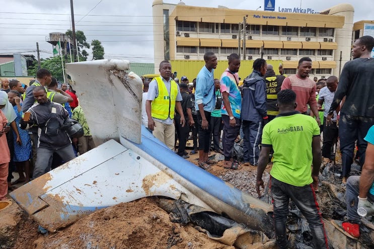 People crowd the wreckage after an aircraft crash landed in the Oba Akran area on August 1, 2023. Credit: NEMA / Twitter