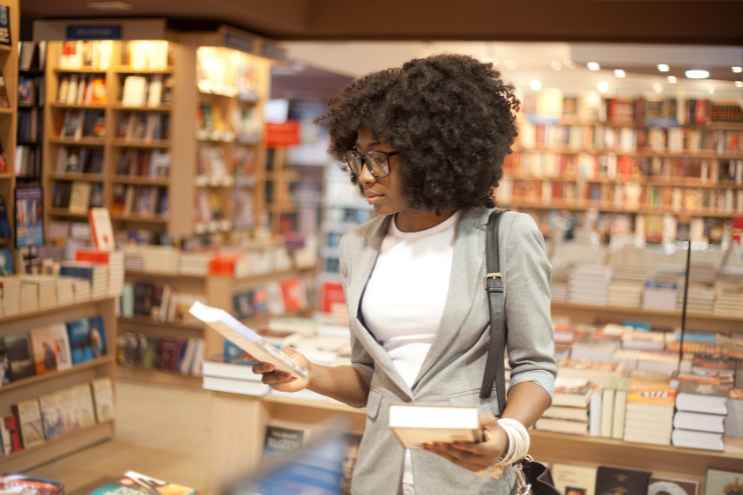 A woman checks out a book inside a bookstore.